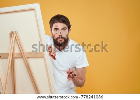  man artist with an easel on a yellow background                              