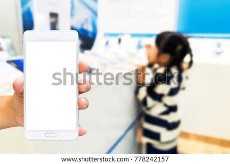 Girl use mobile phone, blur image of child playing mobile in a mobile store as background.