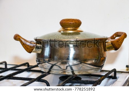 A small silver Pot on a gas stove
