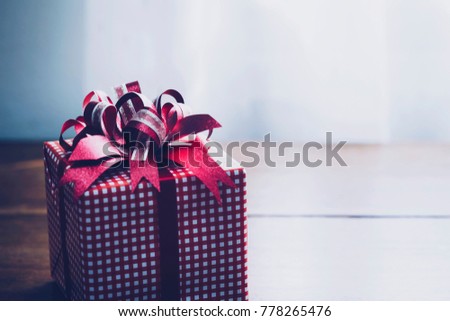 The gift box on wooden table background with window light and shadow, copy Space for your text