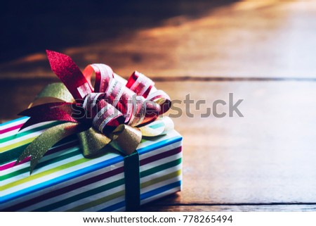The gift box on wooden table background with window light and shadow, copy Space for your text