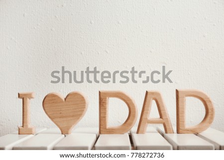 Phrase "I love dad" made of wooden letters as greeting for Father's day on table