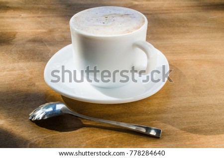Cappuccino or coffee latte with foam in white cup and the Inscription Good Morning on wooden table. Autumn concept.