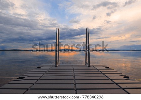 Ladder into a calm lake in the evening sun in northern Finland