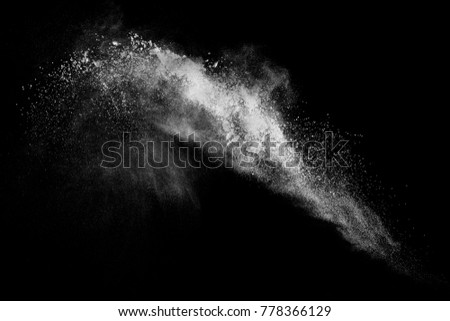 Freeze motion of white dust explosion on black background. 
