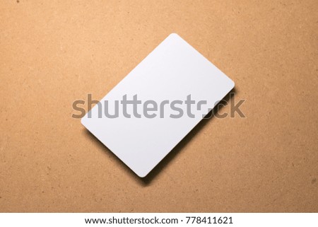 White card on wooden background. Template of cardboard paper for design.