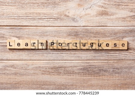 learn portuguese word written on wood block. learn portuguese text on table, concept.