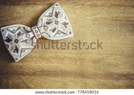 Embroidered Bow Tie on Wooden Brown Background. Father's day Concept. Rustic Style