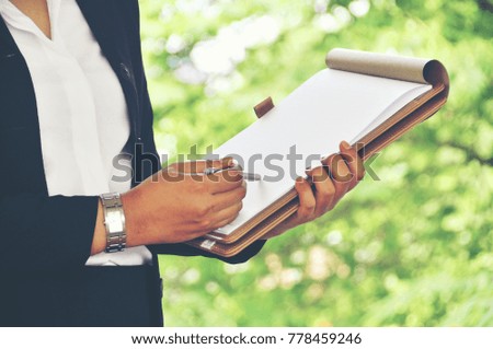 Young business women’s hand hold notebook. Graphs Concept