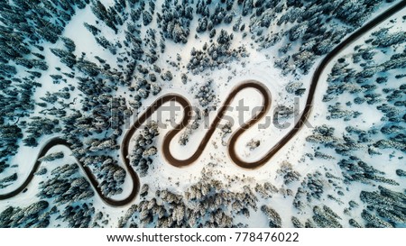 Top aerial view of snow mountain landscape with trees and road. Dolomites, Italy. Royalty-Free Stock Photo #778476022
