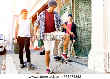 Teenage friends walking at the street with skateboards