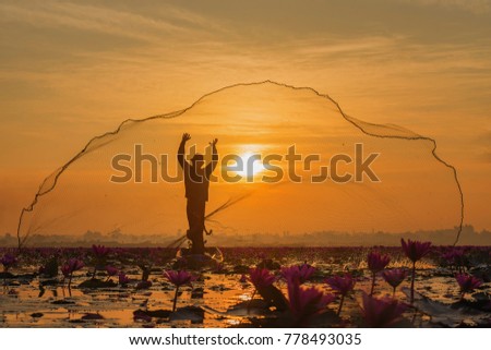 Fishermen fishing in the early morning golden light,fisherman fishing in the river with Lotus,Thailand,Vietnam,myanmar,Laos