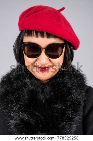 Closeup Shot of an Asian Woman with Short Hair Wearing a Red Beret, Pair of Cool Sunglasses and a Black Wool Coat with a Faux Fur Collar