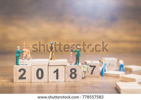 Miniature people : Worker team building wooden block number 2018 on wooden background