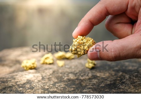 The pure gold ore found in the mine is in the hands of men Royalty-Free Stock Photo #778573030