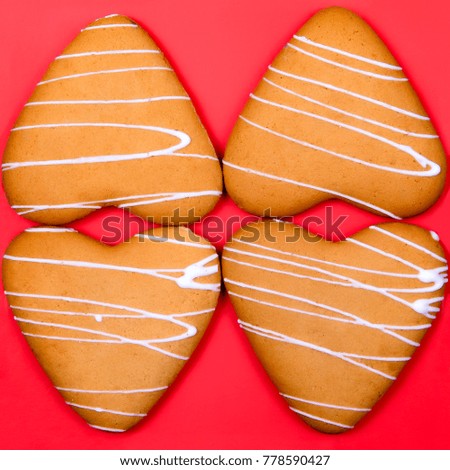 four heart-shaped cookies on a red background