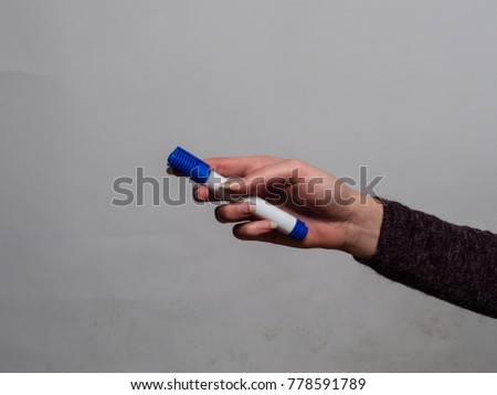 Soft female hand holding various objects with gel fingernails