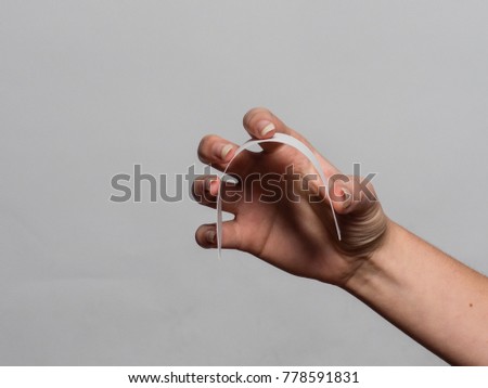 Soft female hand holding various objects with gel fingernails