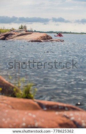 An active senior paddling a sea kayak on Georgian Bay, Ontario, Canada. 