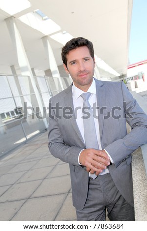 Handsome businessman standing in front of building