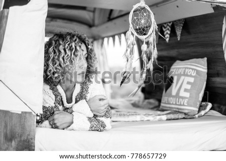 black and white photo of woman with curly hair at the edge of an old van