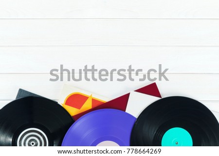 Holiday postcard frame. Background of vinyl records DJs for a music player on a white wooden background close-up. Red, black, violet  vinyl records. Turntable audio equipment for disc jockey