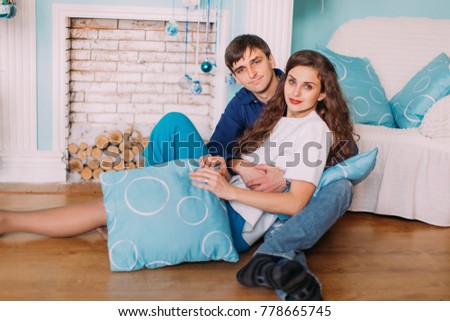 New Year's picture of happy family on background of Christmas decorations. Beautiful young couple hugging and smiling