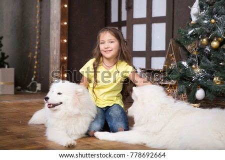 Happy Little girl with a dog  at home  in Christmas.