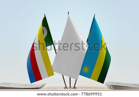 Flags of Comoros and Rwanda with a white flag in the middle
