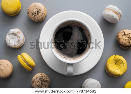 aroma coffee cup with sweet colorful macaroons cake on a table, top view
