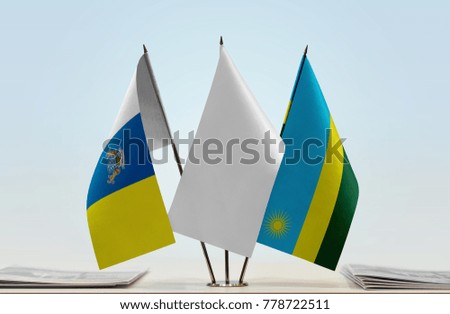Flags of Canary Islands and Rwanda with a white flag in the middle