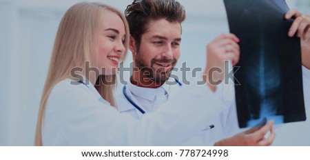 medical and radiology concept - two doctors looking at x-ray