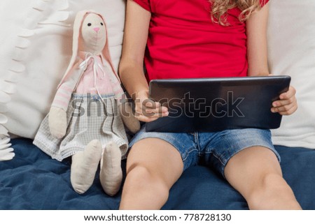 Child watching cartoon, video on her tablet. Rest at home.