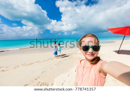 Little girl making selfie while having tropical beach vacation with her family