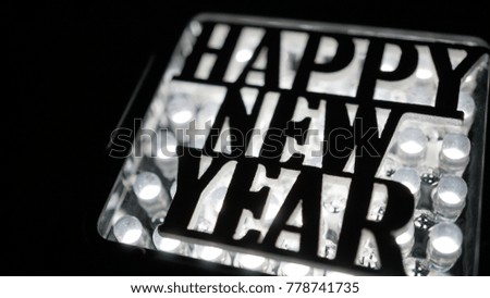 happy new year lettering in silhouette with led background
