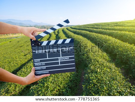 Man hands holding movie clapper isolated on nature background. Shown slate board. use the colors white and black.Realistic movie clapperboard. Clapper board isolated.Film director concept.