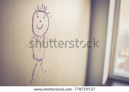 Crayon sketch of a happy child made on a closet by a child