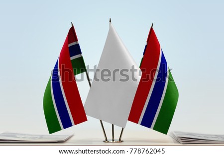Two flags of The Gambia with a white flag in the middle