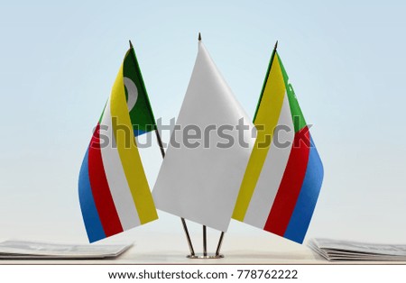 Two flags of Comoros with a white flag in the middle