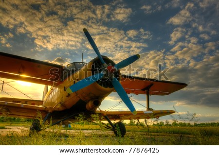 HDR foto of an old airplane on green grass and sunset background Royalty-Free Stock Photo #77876425