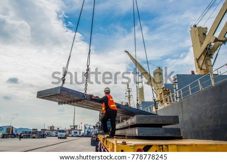 cargo steel slab discharging from the ship vessel laying onto the lorry trailer tier to tier, the shipment export and import under logistics system services to global worldwide transportation Royalty-Free Stock Photo #778778245
