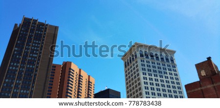 View of high-rise buildings located in downtown Baltimore.  Buildings feature modern architecture.  Beautiful, clear, blue sky seen above the buildings.