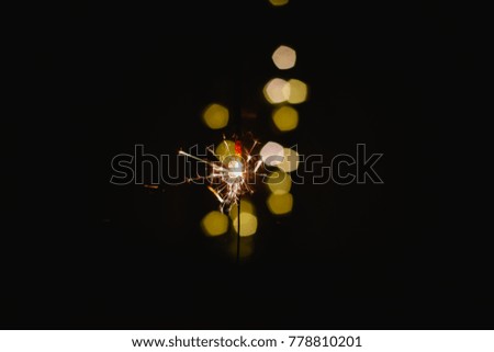Abstract blur sparklers for celebration christmas and happy new year party background,Motion Blurred by wind Sparklers with Pentagon bokeh background.Winter Dark vintage film grain filter style.