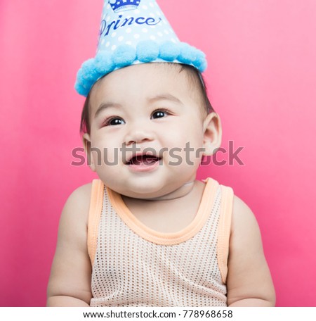 Asia Baby boy wearing birthday party hat on pink background