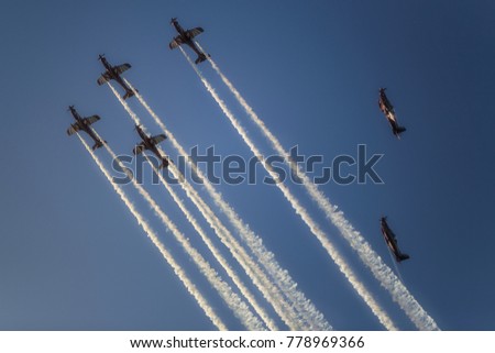 Reactive jet plane flying in formation and leave inversion trail on blue sky