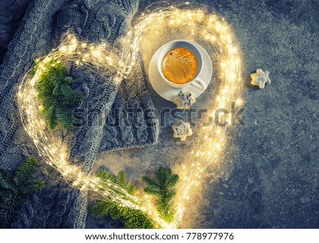 Coffee, cookies, heart shaped lights and Christmas tree branches. Vintage style toned picture