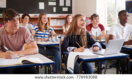 Students Listening To Female Teacher In Classroom Royalty-Free Stock Photo #778983088