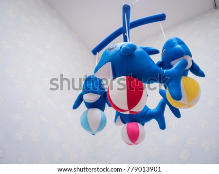 Blue fish doll toys and colorful balls hanging on the wall.