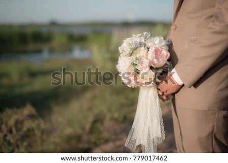 Man hiding behind a bouquet of flowers for marriage girlfriend request, will you marry me