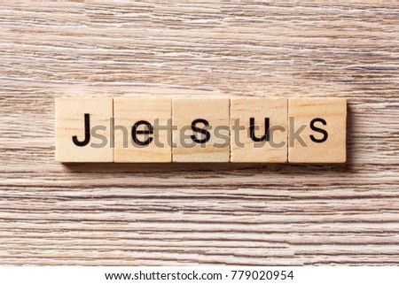 Jesus word written on wood block. Jesus text on table, concept.